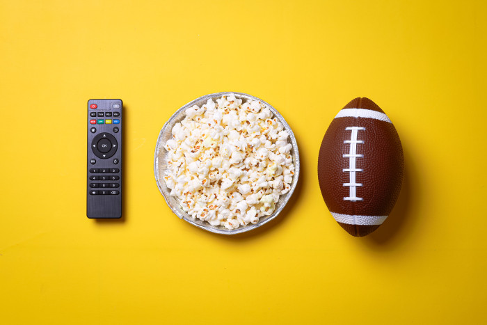 Bowl of popcorn, a football and a remote